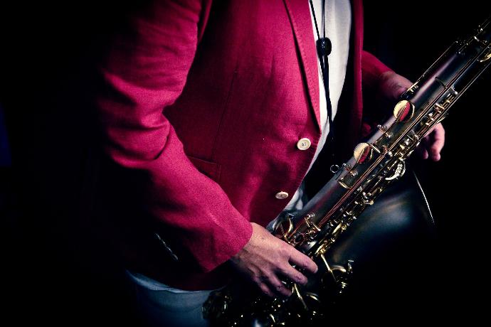 a man in a red suit holding a saxophone
